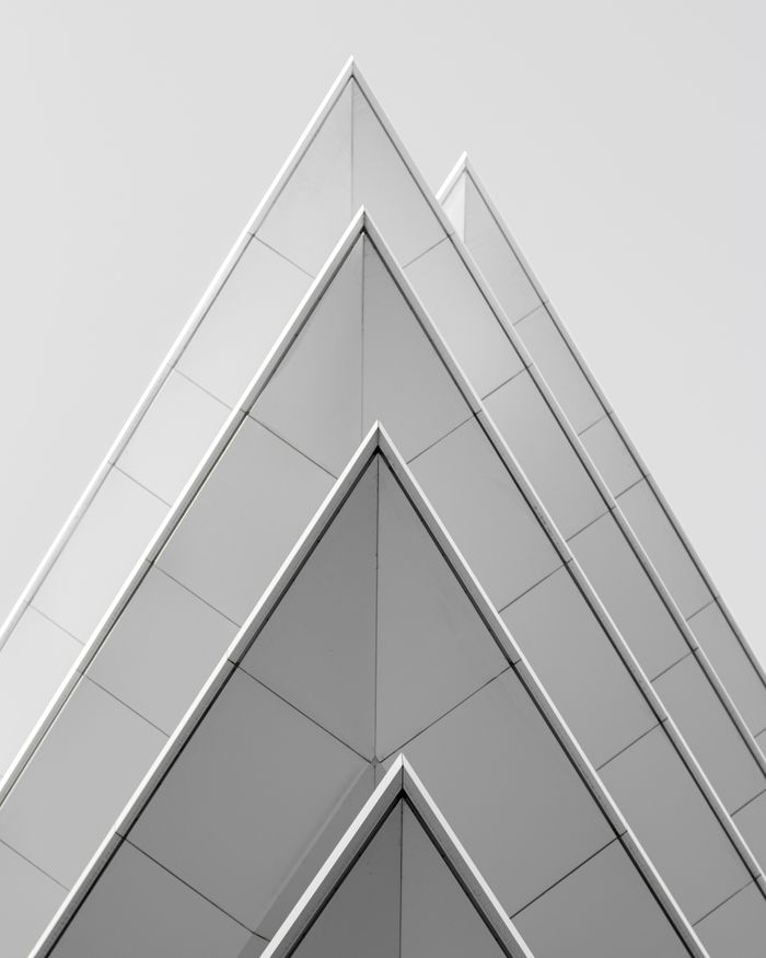 Futuristic pyramid-shaped building facade in Athens, Greece showcasing modern architectural design.