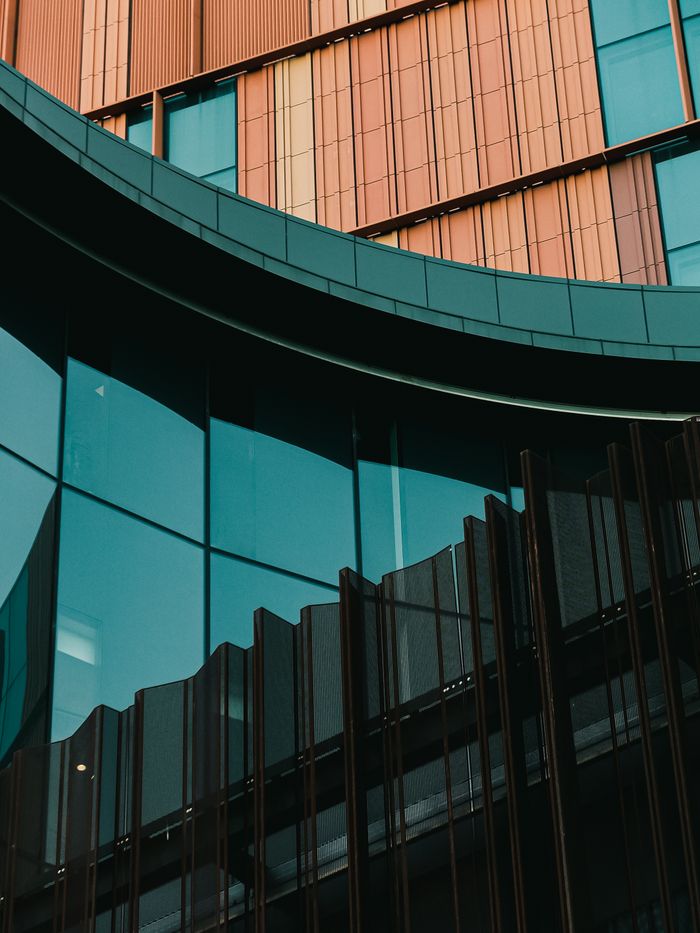 Closeup of a modern building facade with glass and metal elements showcasing urban architecture.